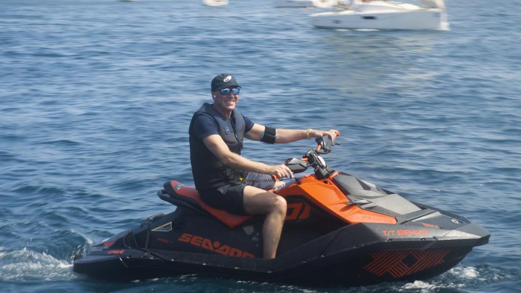 Mark Dyer aka Mr Stingblade riding a jet ski, he has a Stingblade Personal on his right arm